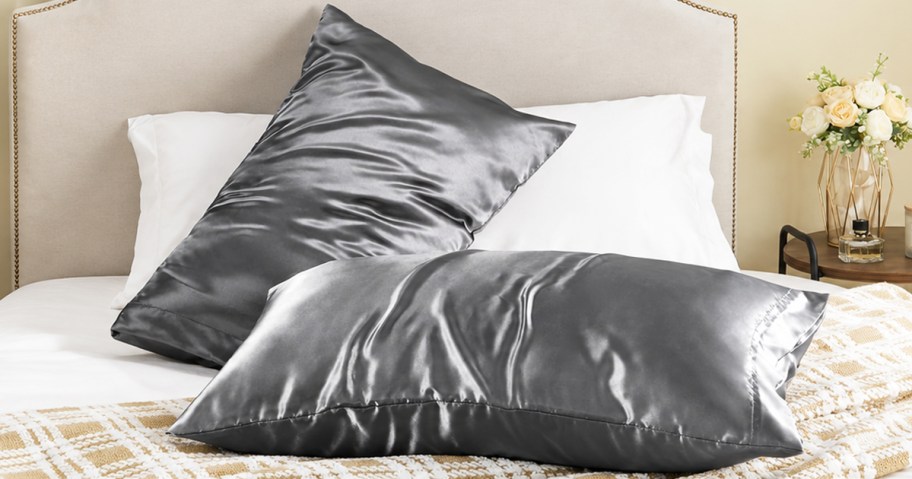 grey satin pillow cases on pillows on a bed