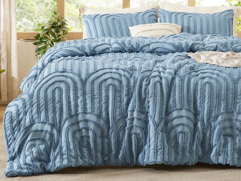 blue arched comforter set and shams on a bed