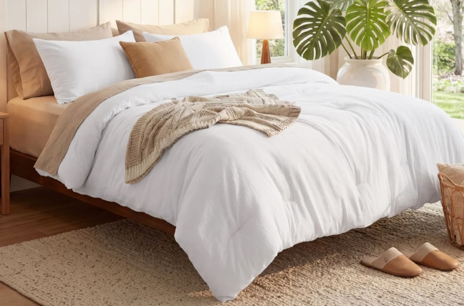 white comforter and shams on a bed with tan sheets