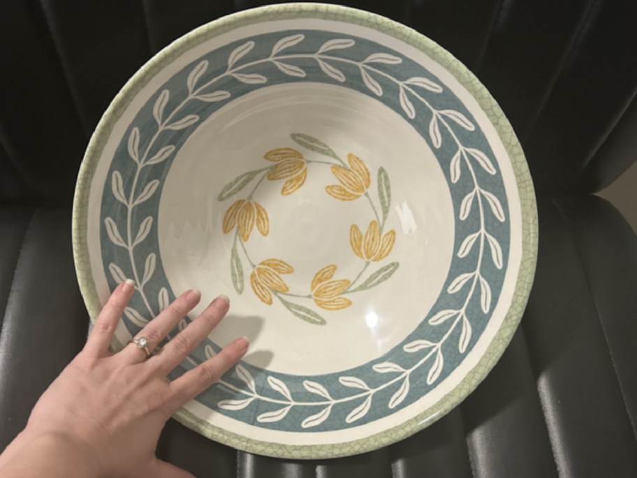 Hand above a Better Homes & Gardens Bamboo Melamine Floral Serve Bowl