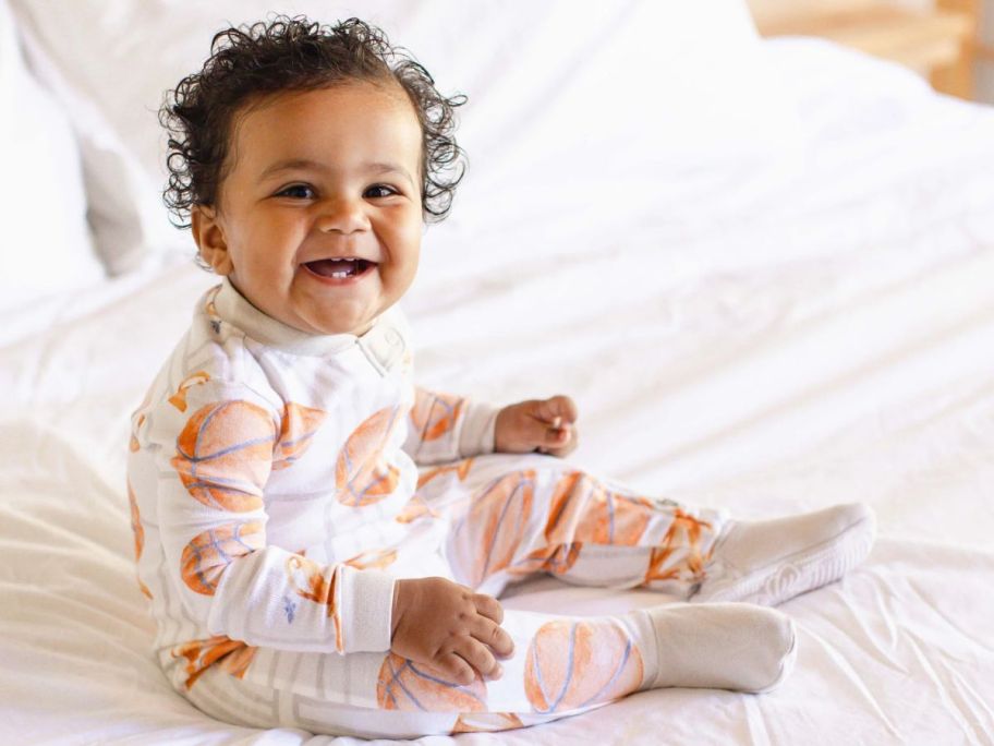 Baby wearing Burt's Bees baby Pajamas with Basketball design on them
