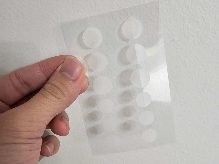 person holding sheet of cetaphil pimple patches against white wall
