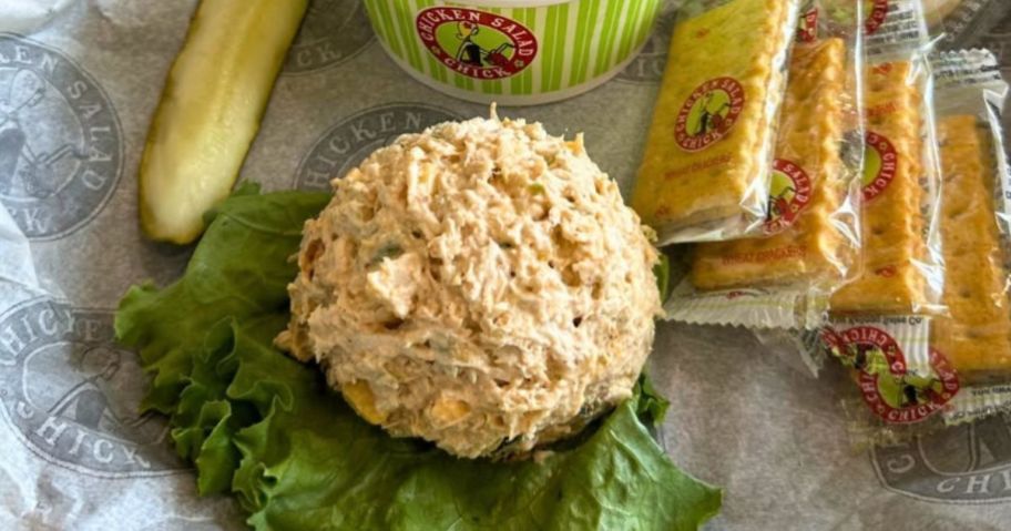 A bed of lettuce with a scoop of Chicken Salad Chick Chicken salad on it
