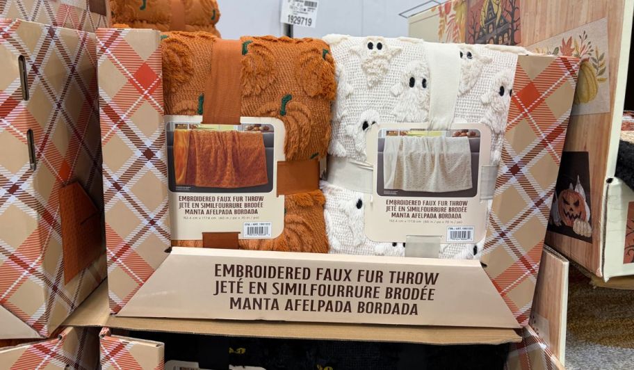 pumpkin and ghost halloween throws displayed at the store inside of shelves
