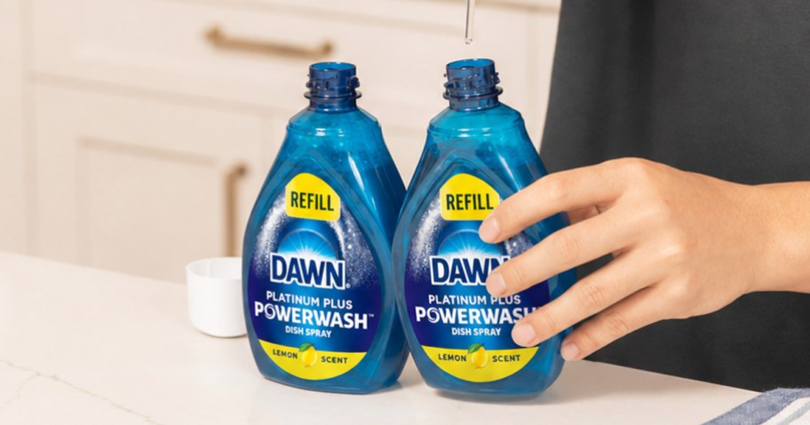 hand holding 2 bottles of Dawn Powerwash refills on kitchen counter