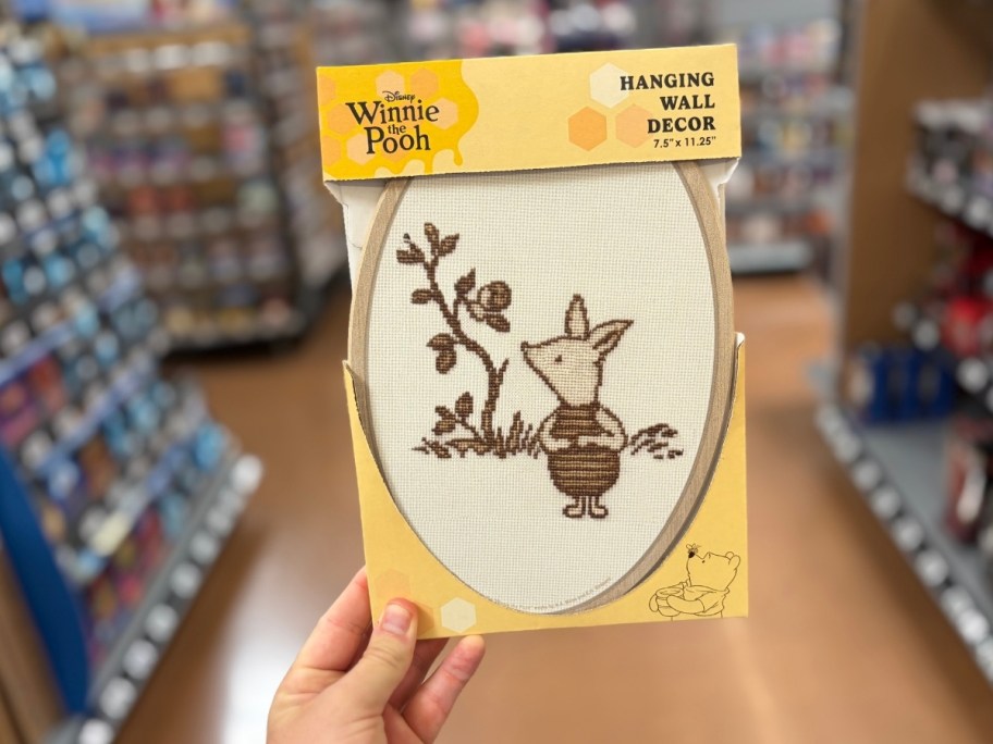 a mans hand holding piglet wall decor