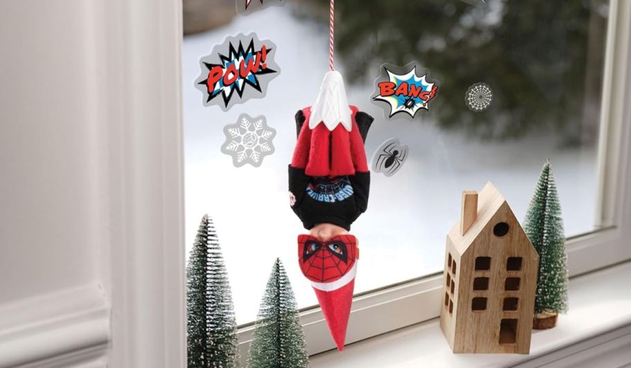 Elf on a shelf spider man displayed on a window 