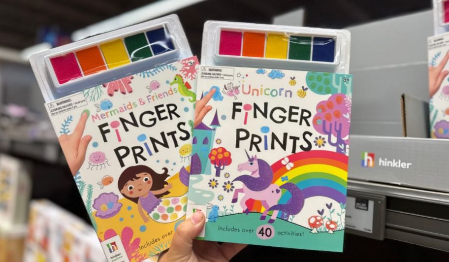 hand holding two Finger prints art books at the store
