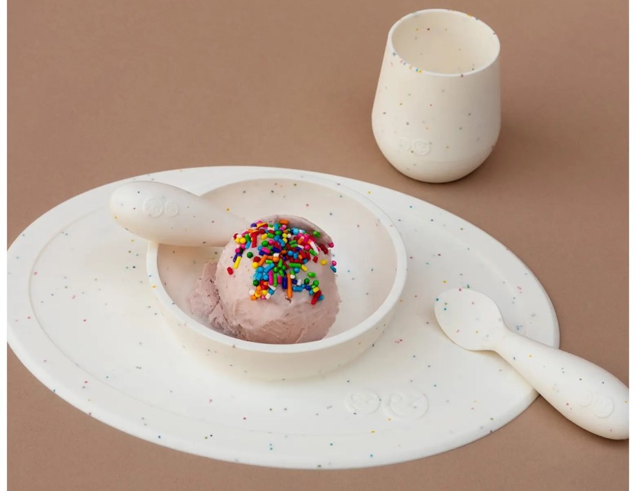 white suction bowl and cup on brown background with rainbow sprinkle ice cream