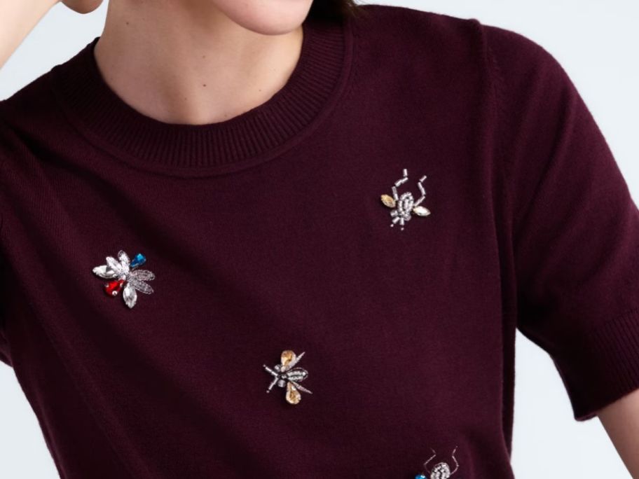 woman wearing a free assembly sweater embellished with jeweled bugs