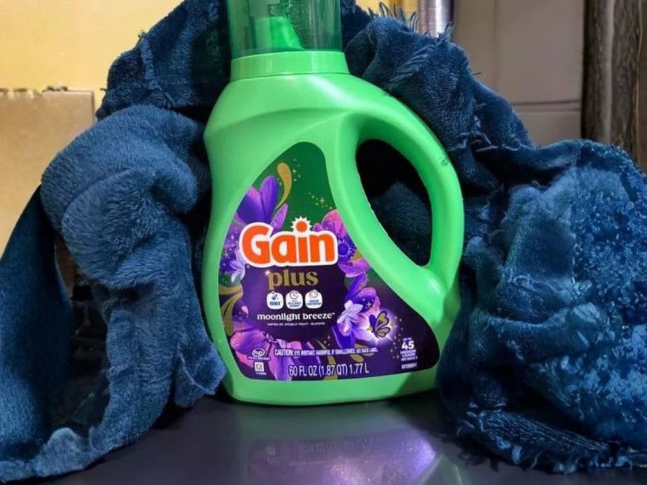 Gain Moonlight Breeze Plus Liquid Laundry Detergent with blanket wrapped around it