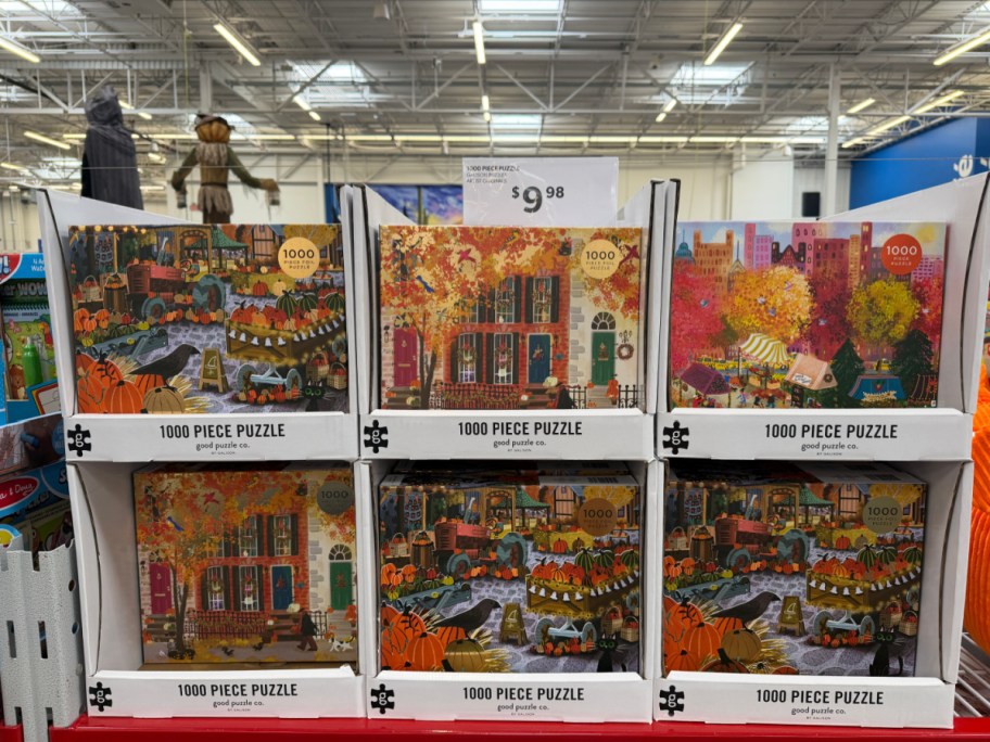 A store display shelf featuring various Galison 1000-piece fall-themed jigsaw puzzles priced at $9.98.