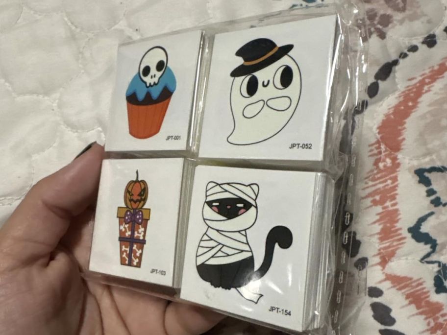 hand holding a packet of glow in the dark Halloween tattoos