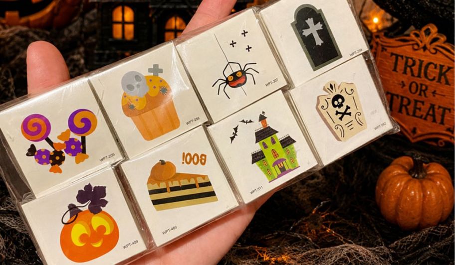 hand holding an array of different Halloween tattoos