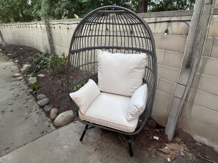 Hampton Bay Breezy Bay Gray Wicker Outdoor Egg Chair with CushionGuard Almond Cushions on a patio