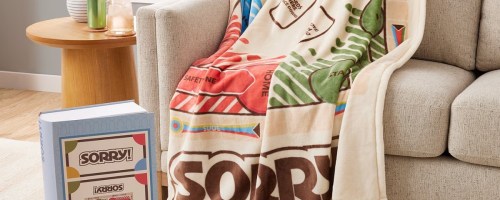 hasbro sorry board game blanket draped over couch with game box and board sitting on floor