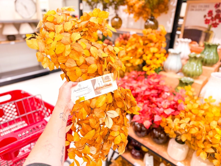 holding a yellow fall garland at Target