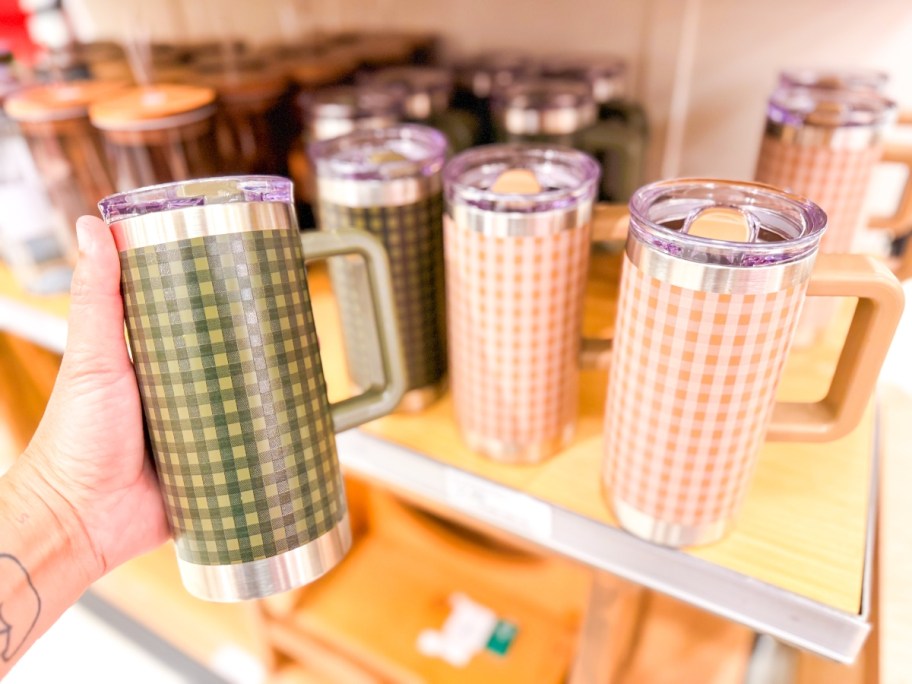holding a gingham stainless steel tumbler