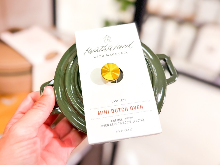 holding a small green dutch oven