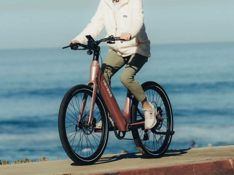 woman riding Heybike Venus eBike next to water