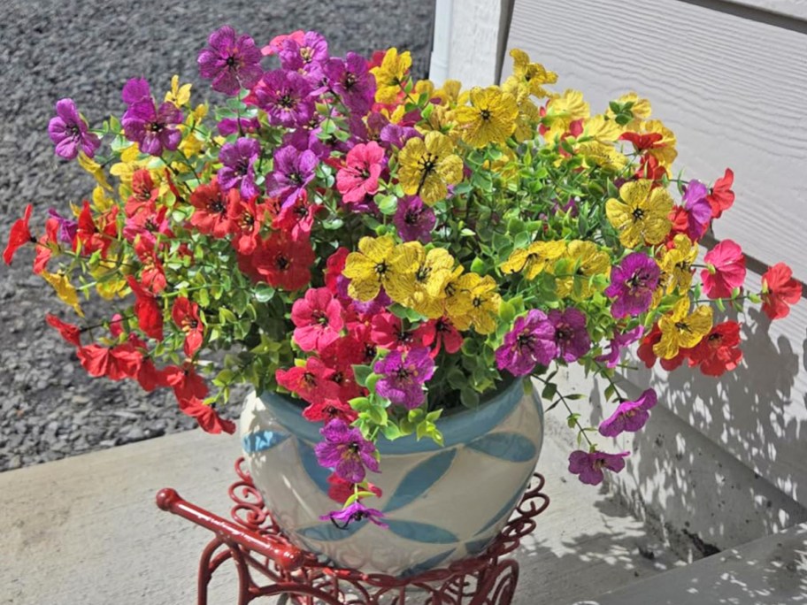 colorful artificial flowers in a stone planter