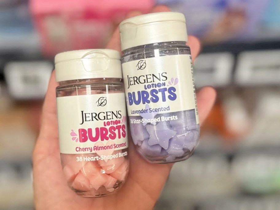 hand holding bottles of lotion bursts in pink hearts and purple stars