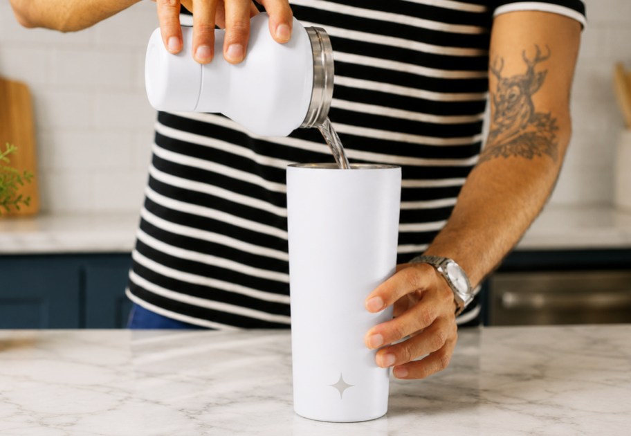 pouring drink into a white shaker bottle