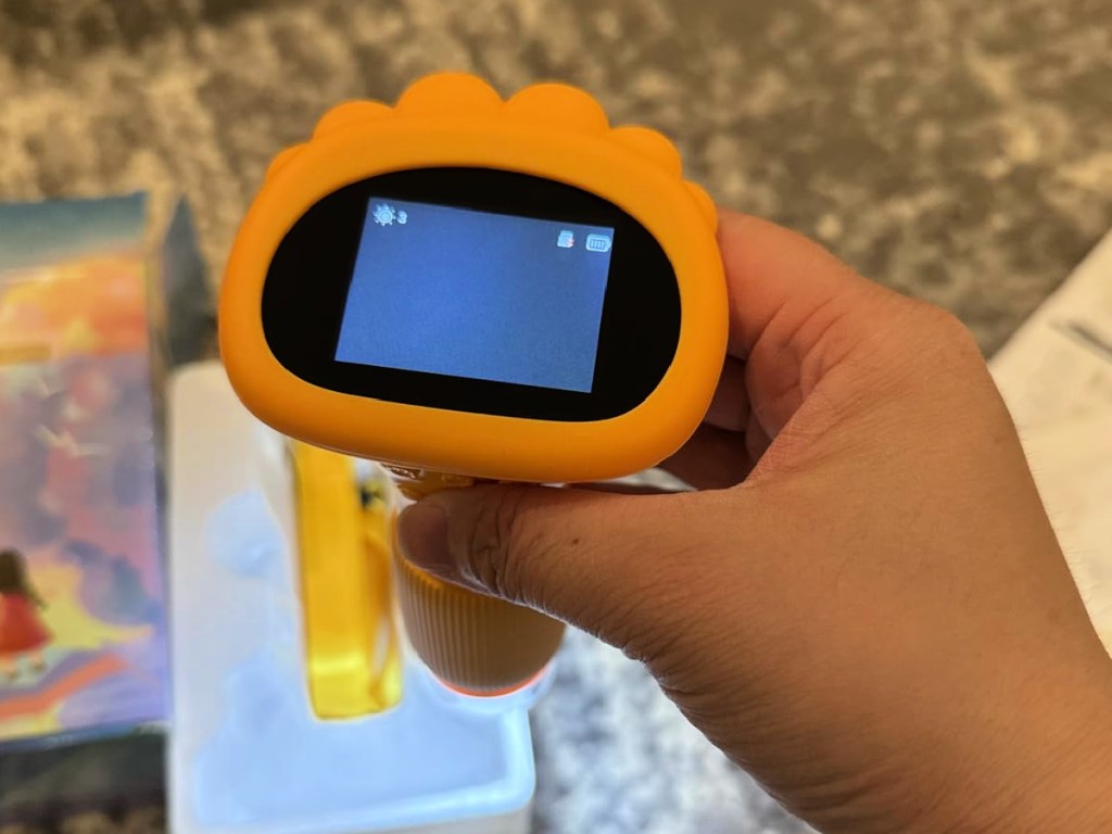 Hand holding yellow kids microscope