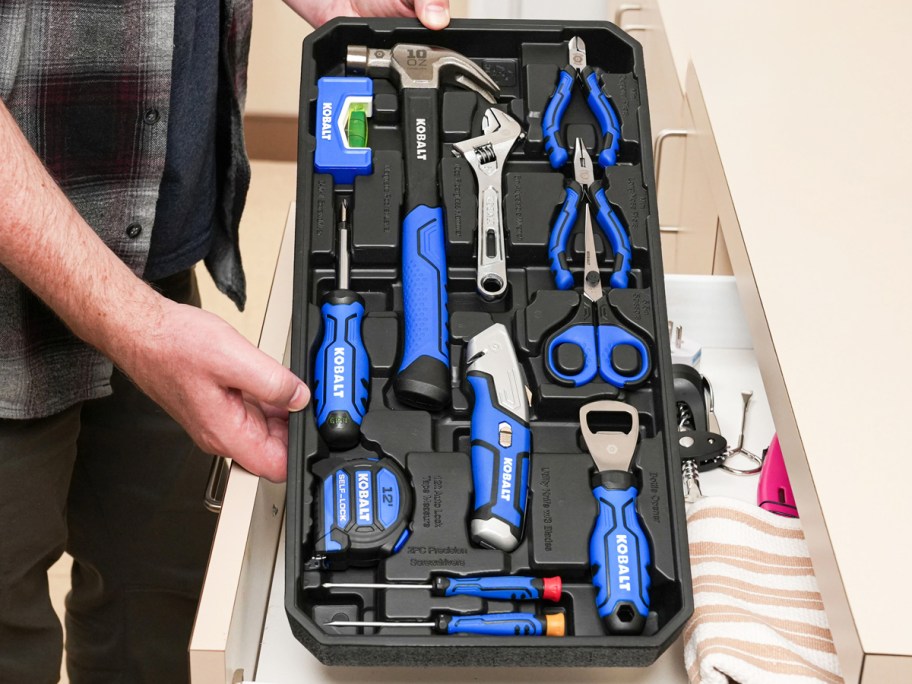 placing a blue and black tool set into a drawer