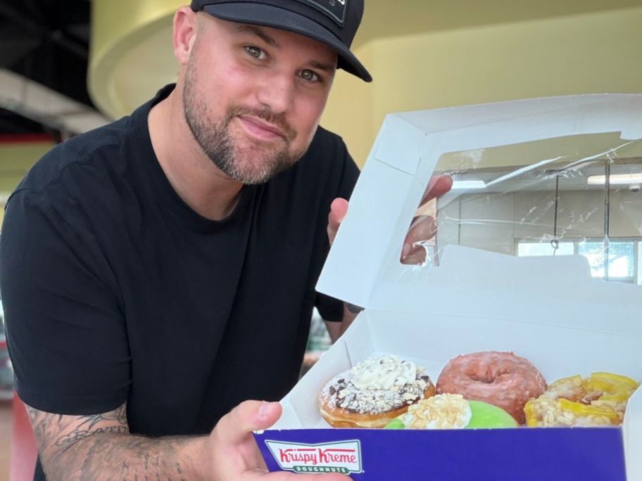 man holding a box of Krispy Kreme Summer Doughnuts