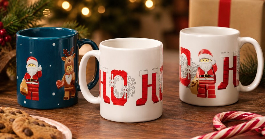 three lego christmas mugs on a table with cookies and candy canes