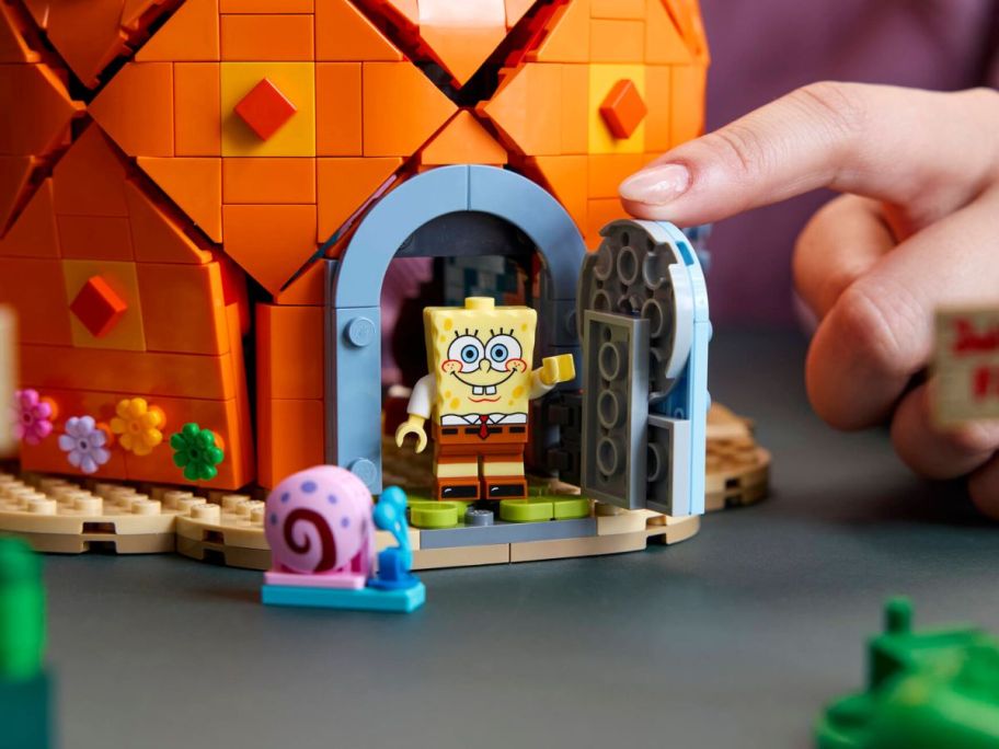 person opening door to LEGO Icons SpongeBob SquarePants Bikini Bottom pineapple
