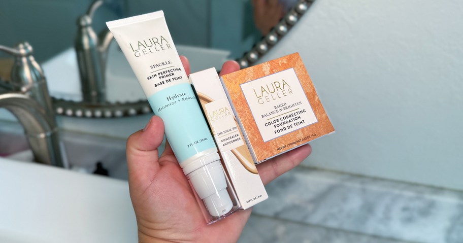 Laura Geller Mature Skin Basics Kit being held in front of a mirror