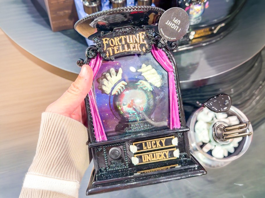 Light-up Glow-in-the-Dark Fortune Telling Candle Pedestal being held in the store