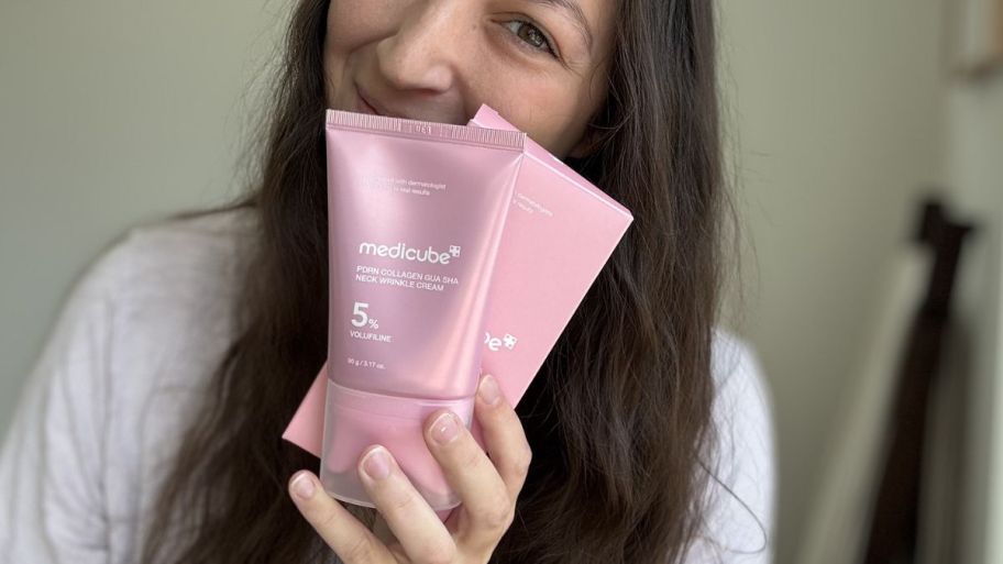 Woman holding Medicube neck cream