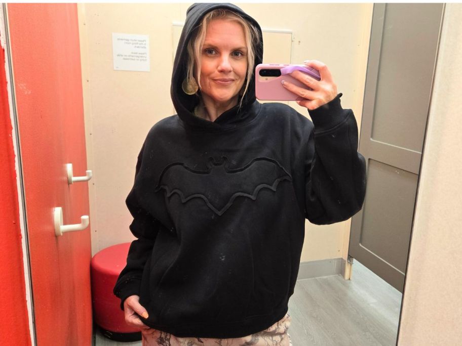 stefanie wearing Modern Lux Women's Bat Oversized Hooded Graphic Pullover Sweatshirt in store fitting room