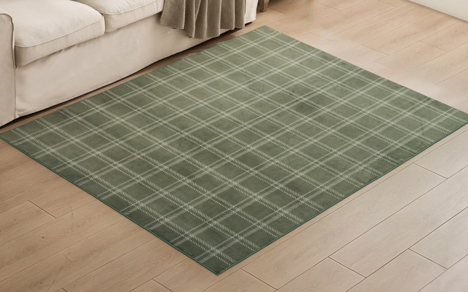 white and green plaid rug in front of a sofa