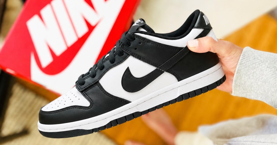 hand holding a black and white nike dunk sneaker