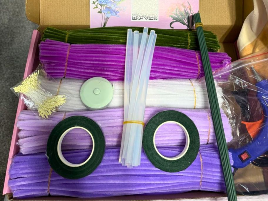 Pipe cleaner flower kit inside of its box with multiple shades of purple