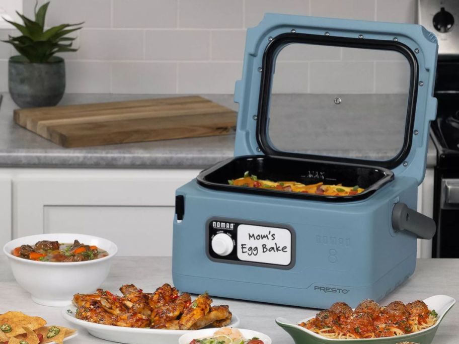 Presto 8-Quart Traveling Slow Cooker on counter with food around it