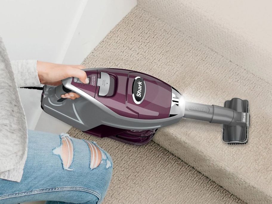 person using Shark Rocket Pet Plus Corded Stick Vacuum on stairs