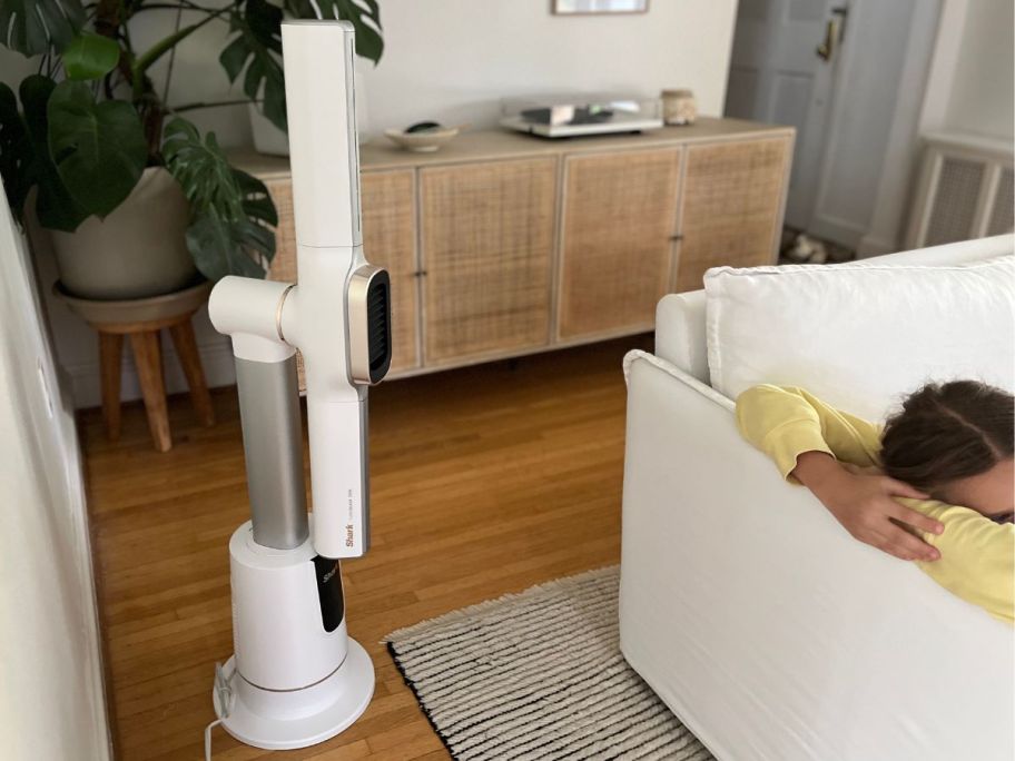 Couch with a young girl laying on it with a Shark Turboblade Tower fan & Heater blowing on her