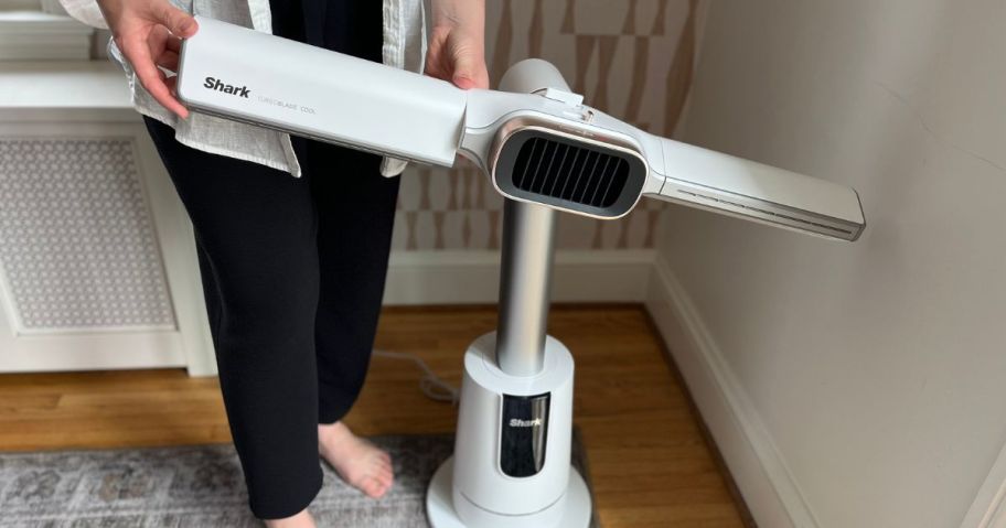 Woman adjustaing a Shark TurboBlade Tower Fan & Heater 