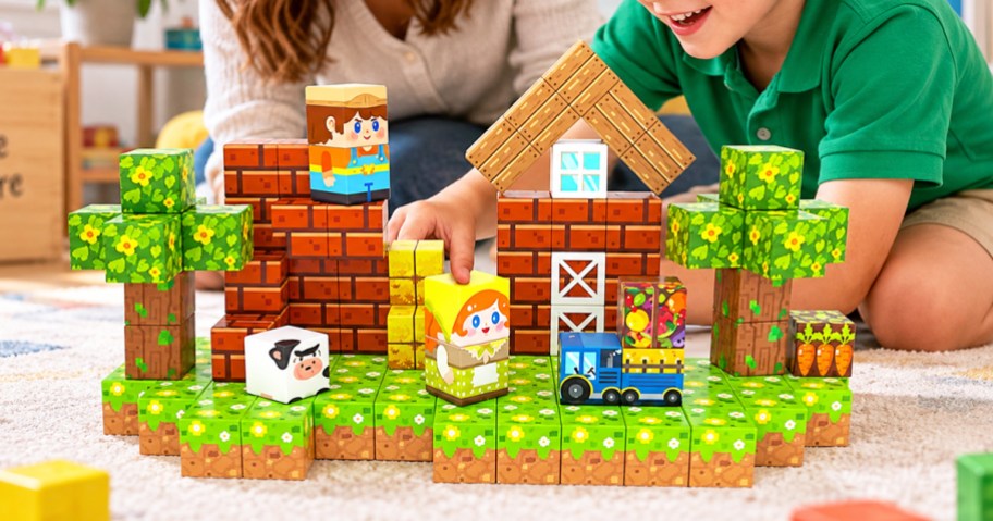 boy playing with a farm theme building blocks set on floor
