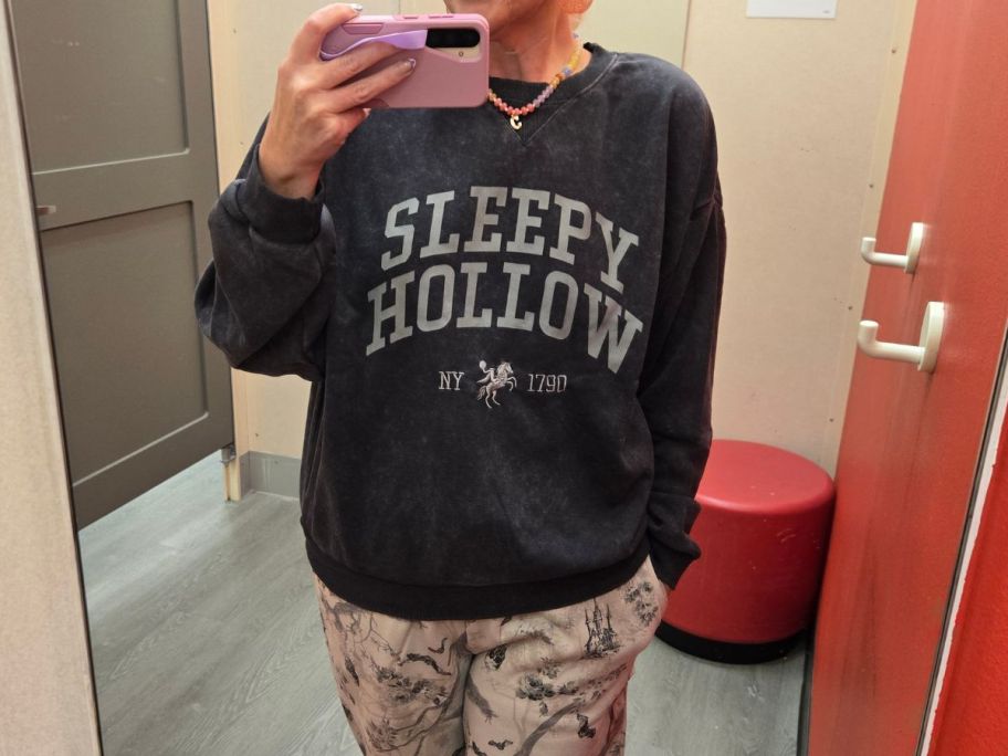 stefanie wearing Special Thanks Women's Crewneck Sleepy Hollow Graphic Sweatshirt in store fitting room