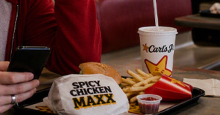 Spicy chicken Max sandwich on food tray next to Carl's Jr. drink and french fries