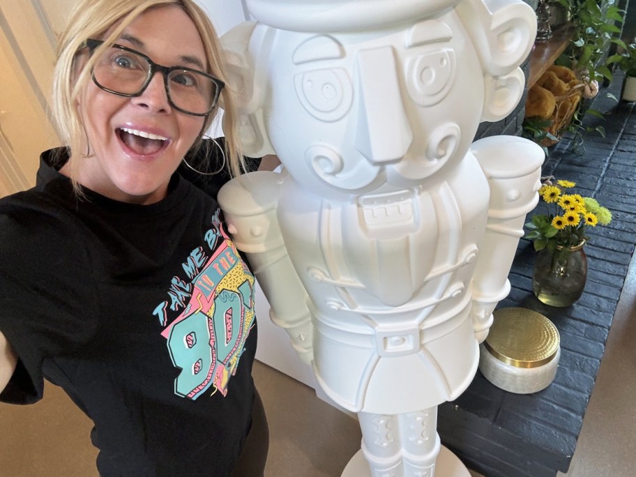 Woman taking selfie with big white nutcracker decoration