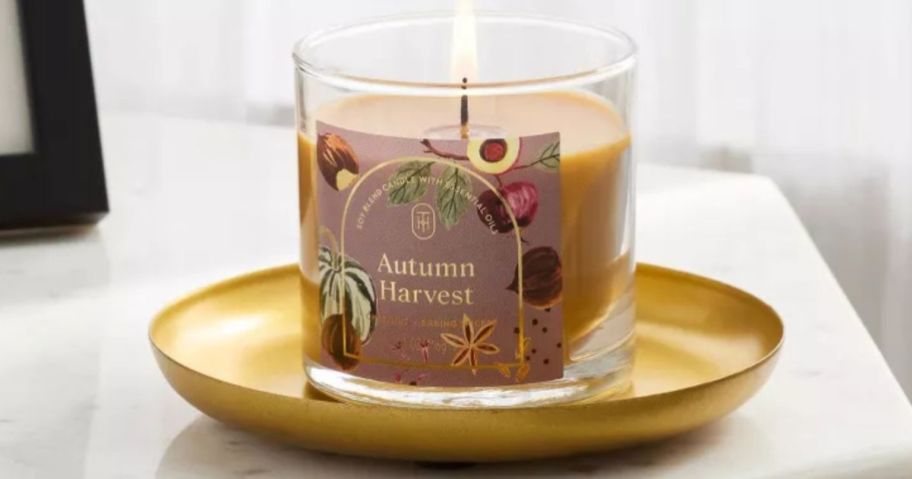 Threshold glass jar candle in autumn harvest lit on side table