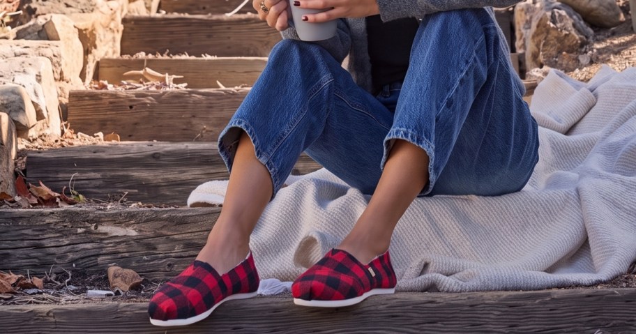 red and black plaid toms shoes on a woman's feet