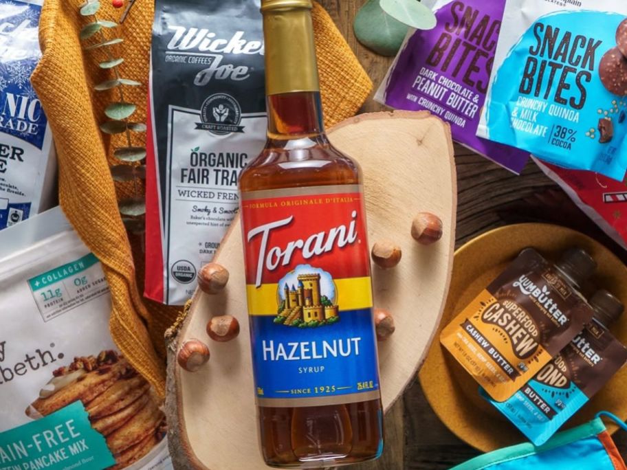 A bottle of Torani Hazelnut Syrup on a bed of various coffee products